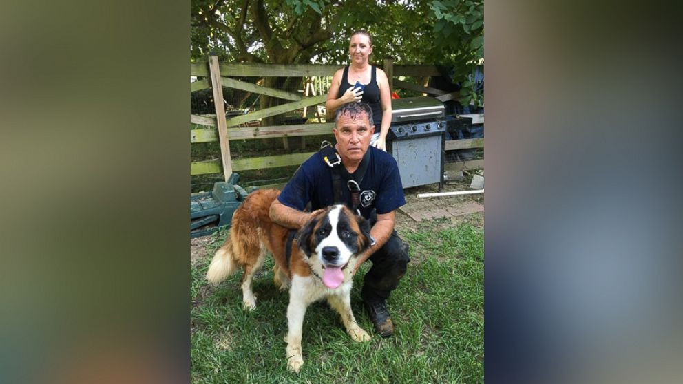 After the rescue, Harford Technical Rescue Crew Chief Dan Lemmon takes a picture with Mabel, rescued from the bottom of a 30-foot well. Her owner stands in the background. 