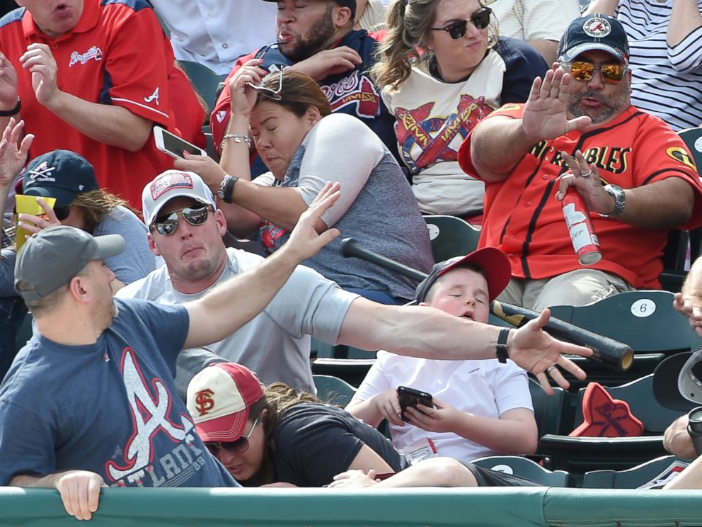 PHOTO: A fan knocks down a bat thrown into the stands by the Pirates' Danny Ortiz during a spring training game against the Braves on March 5, 2016, at Champion Stadium in Lake Buena Vista, Fla.