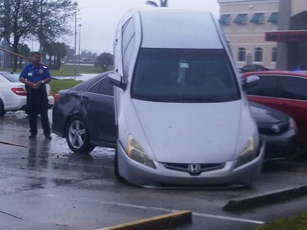 PHOTO:A car sits atop another in the Broward College parking lot after tornado-like winds wrecked havoc in South Florida.  