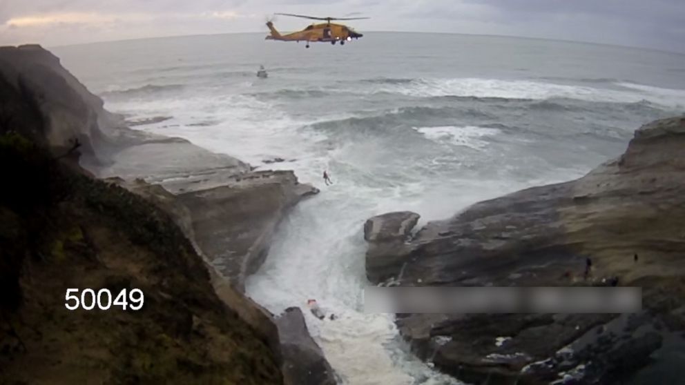 This still image from an Oregon State Police trooper's body cam captured a United States Coast Guard crew rescuing two members of the North Lincoln Fire and Rescue on Feb. 1, 2016.