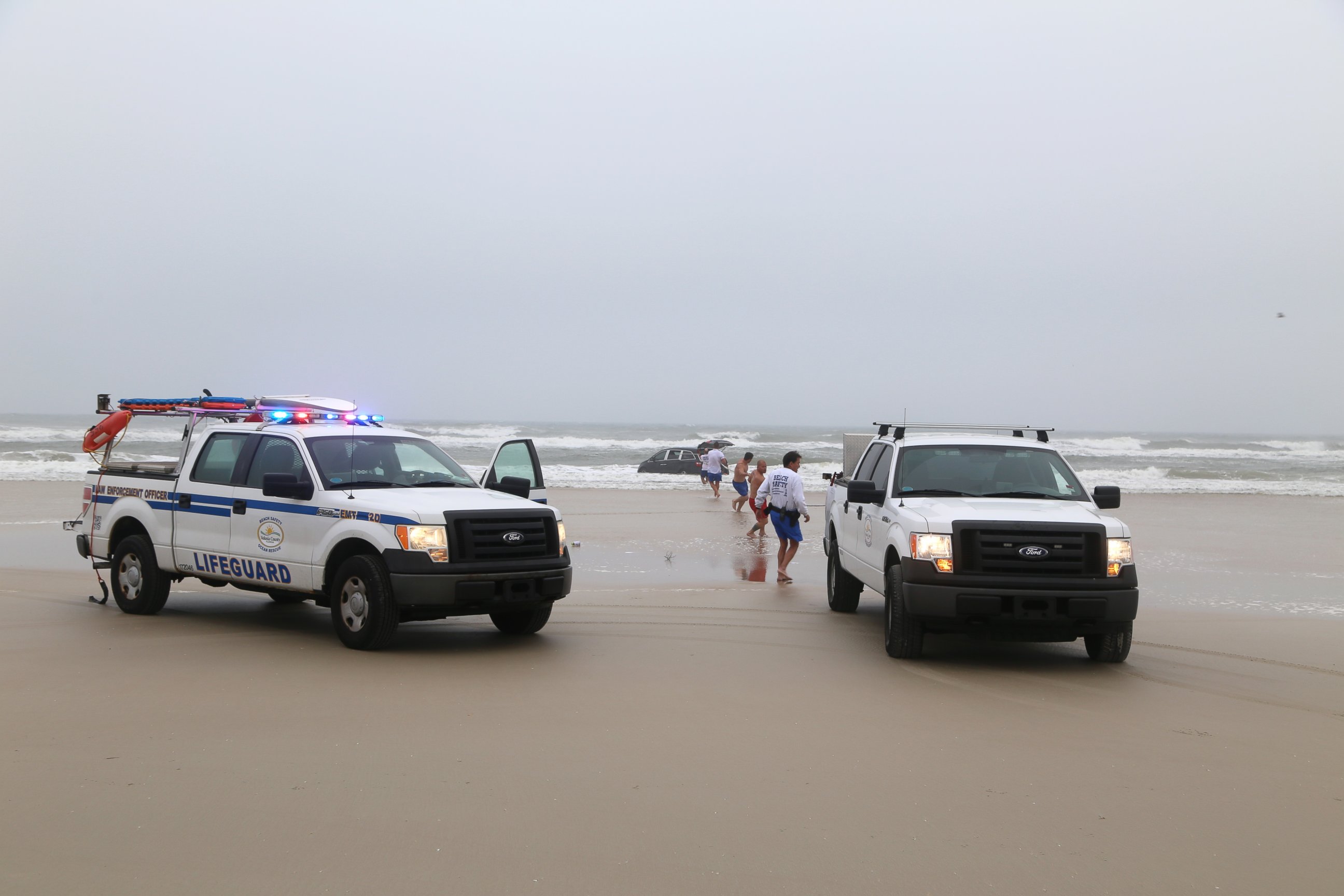PHOTO: Lifeguards on scene to help rescue a family after a mother drives her car in to the ocean, March 5, 2014 in Daytona Beach, Fla.