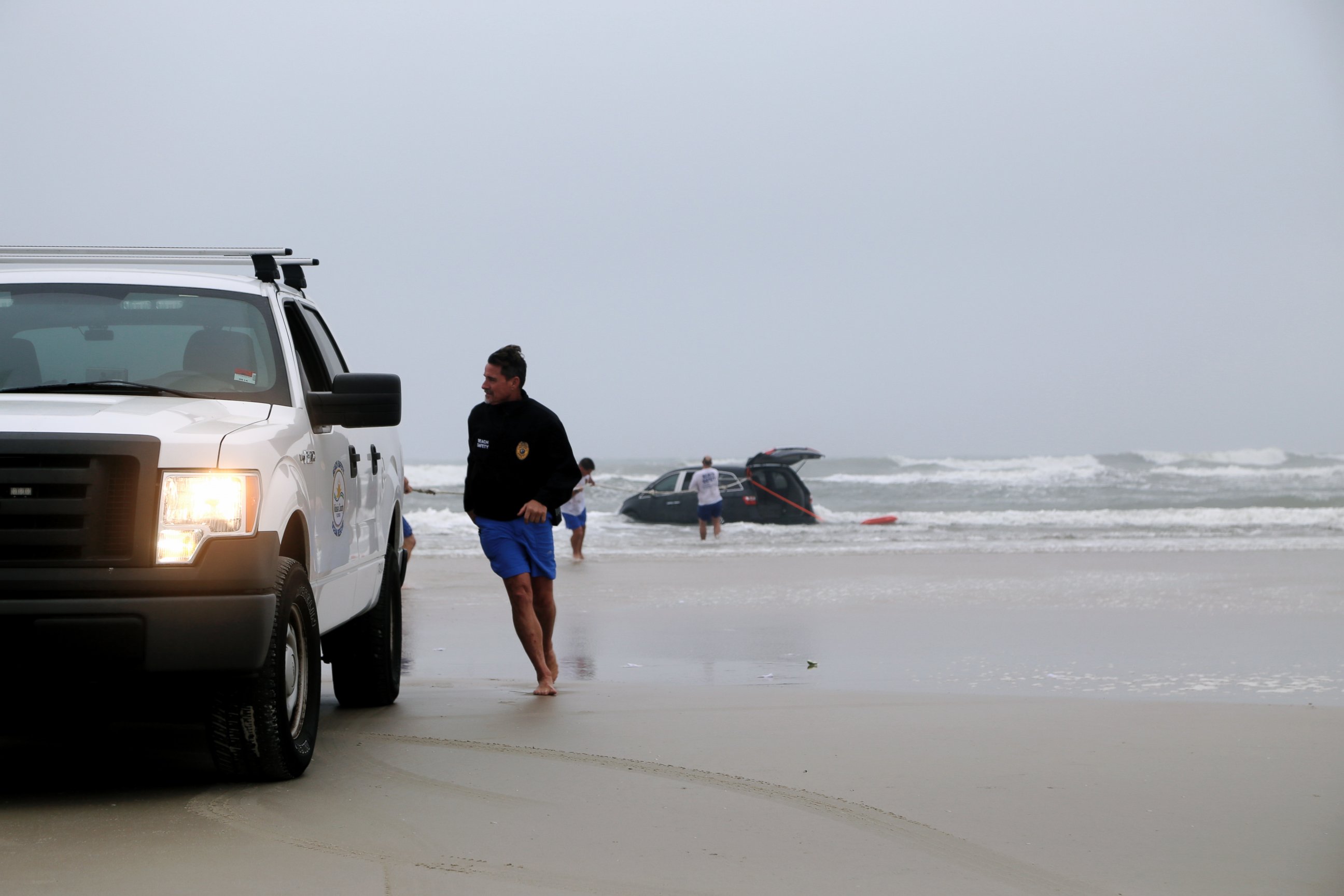 PHOTO: Lifeguards on scene to help rescue a family after a mother drives her car in to the ocean, March 5, 2014 in Daytona Beach, Fla.