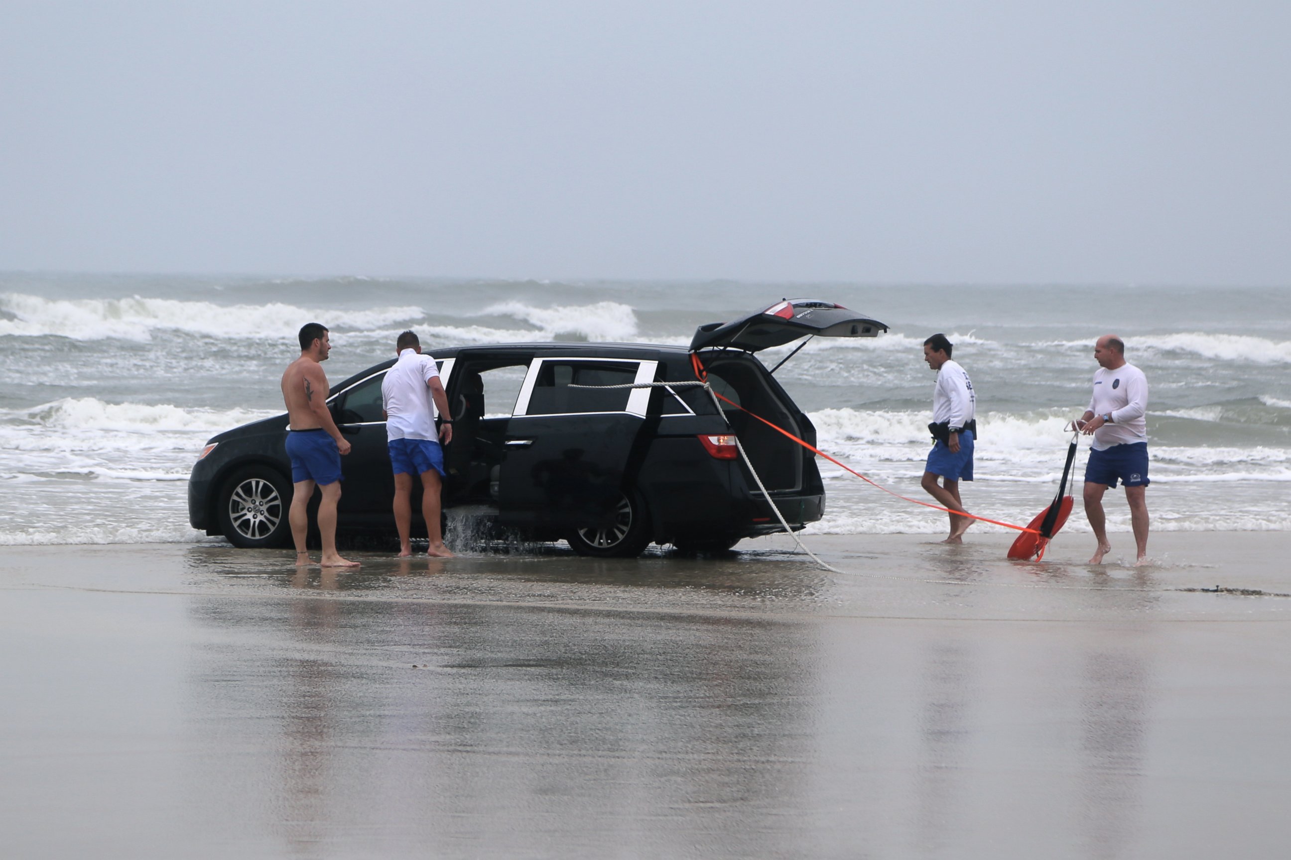PHOTO: A family is rescued after a mother drives her car in to the ocean, March 5, 2014 in Daytona Beach, Fla.