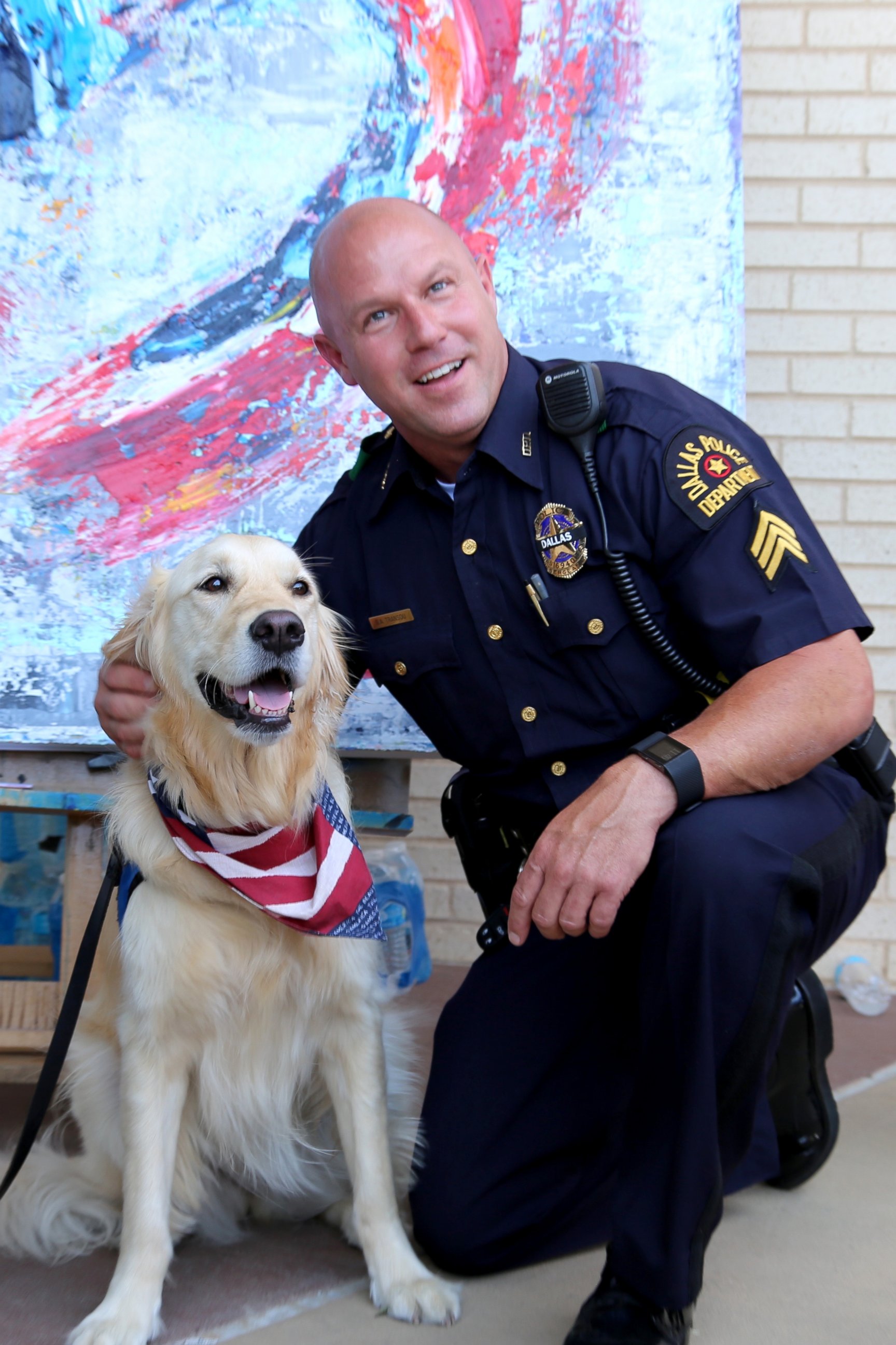 PHOTO: A comfort dog poses with a police officer at the Dallas Police Headquarters. 