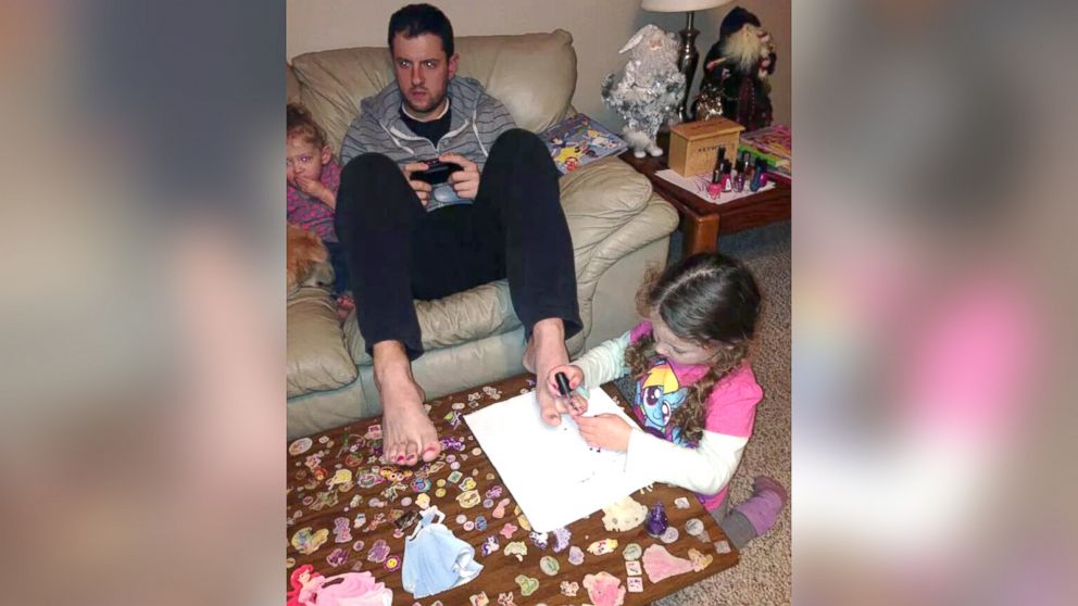When Jon Arrigo posted a photo of himself playing video games while his baby daughter sat beside his and his 3-year-old daughter painted his toenails, the 28-year-old father never expected it would draw such a strong reaction.