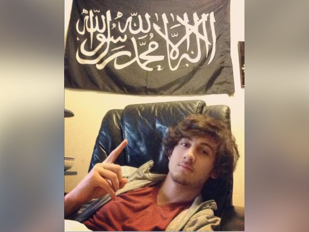 PHOTO: Prosecutors introduced a new photo today at the trial of alleged Boston Marathon bomber Dzhokhar Tsarnaev showing Tsarnaev posing under a black flag with white and black Arabic writing -- a banner often used by al Qaeda groups. 