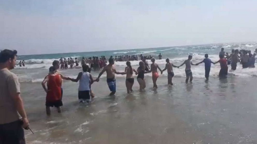 VIDEO: Beachgoers form human chain in attempt to rescue swimmers