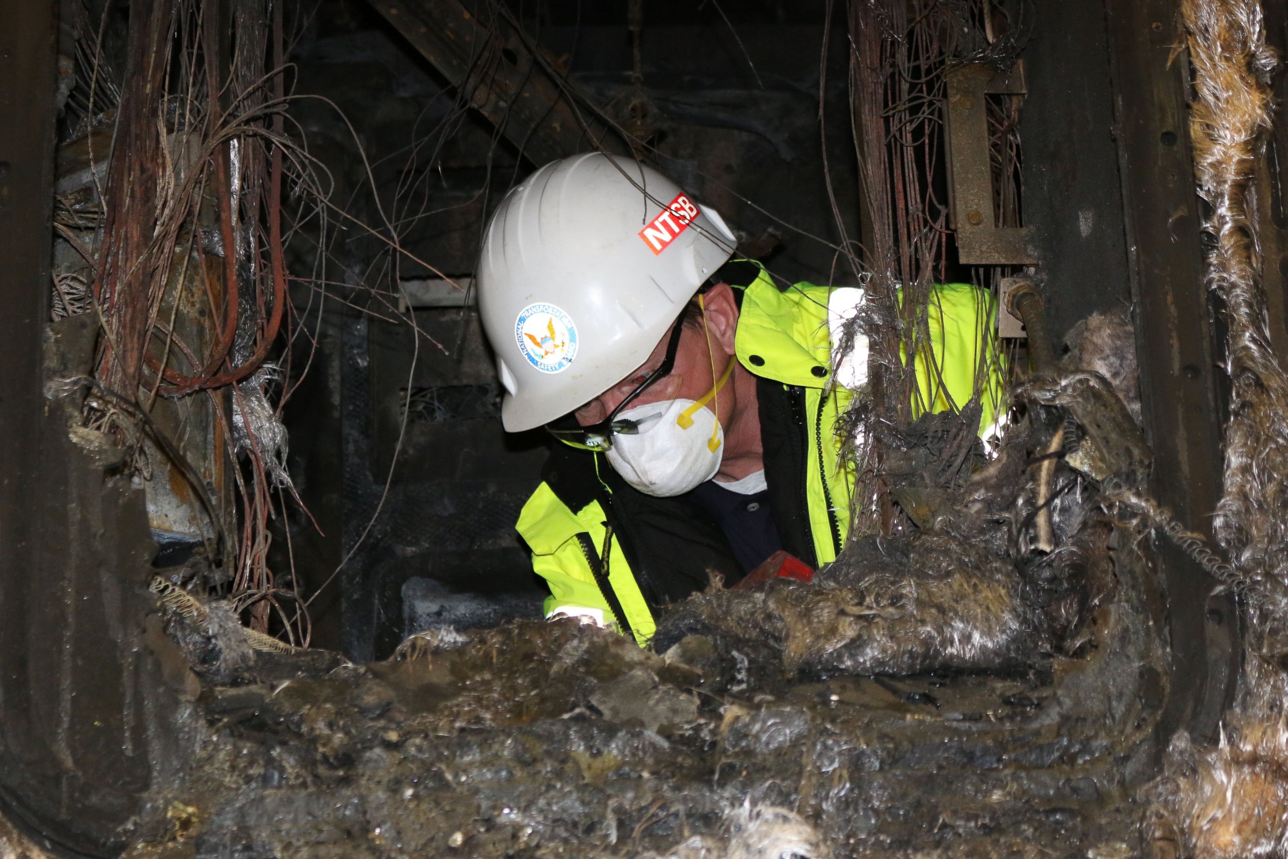 PHOTO: In this photo posted to Flickr by the National Transportation Safety Board, an inspector examines inside a burned unit from the Metro-North accident.