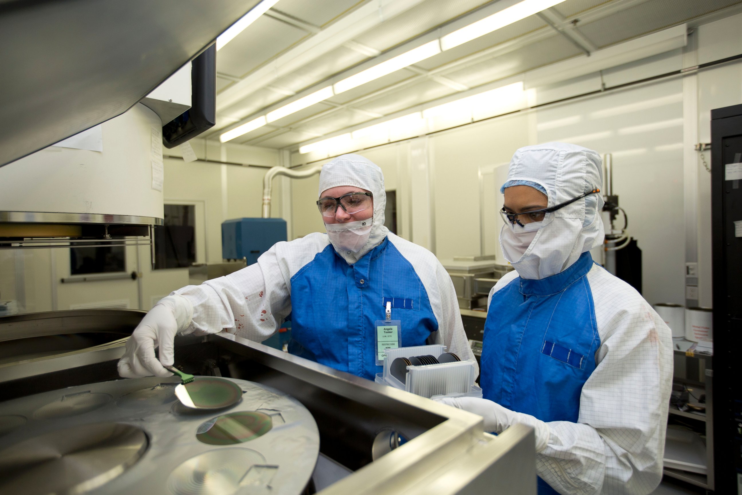 PHOTO: Lawrence Livermore engineers Angela Tooker and Vanessa Tolosa load silicon wafers into a metal deposition chamber during the development of neural devices.