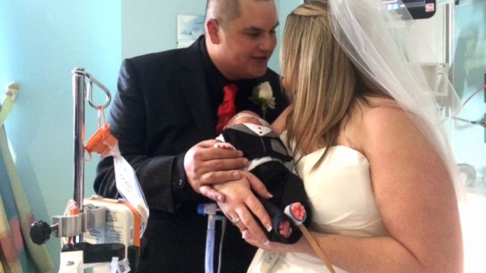 PHOTO: Kristi Warriner and Justin Nelson hold their baby, J.J., during their wedding ceremony at Cook Children's Hospital in Texas. 