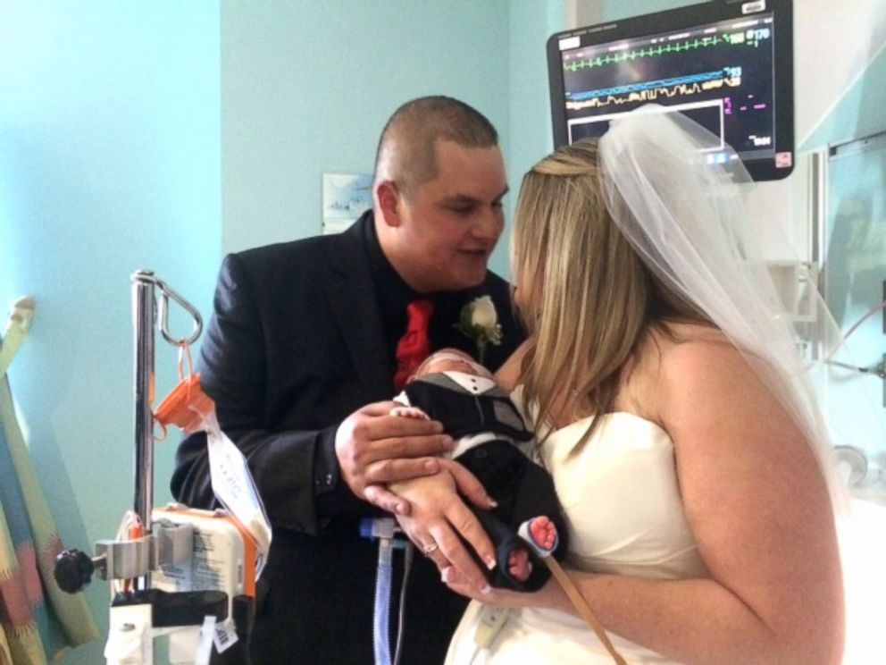 PHOTO: Kristi Warriner and Justin Nelson hold their baby, J.J., during their wedding ceremony at Cook Children's Hospital in Texas. 