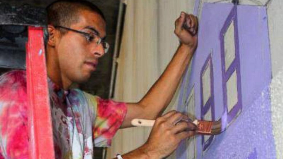 Muralist Antonio "Tony" Ramos, seen painting, was shot and killed last year. His family is filing a claim against ICE over a stolen gun.