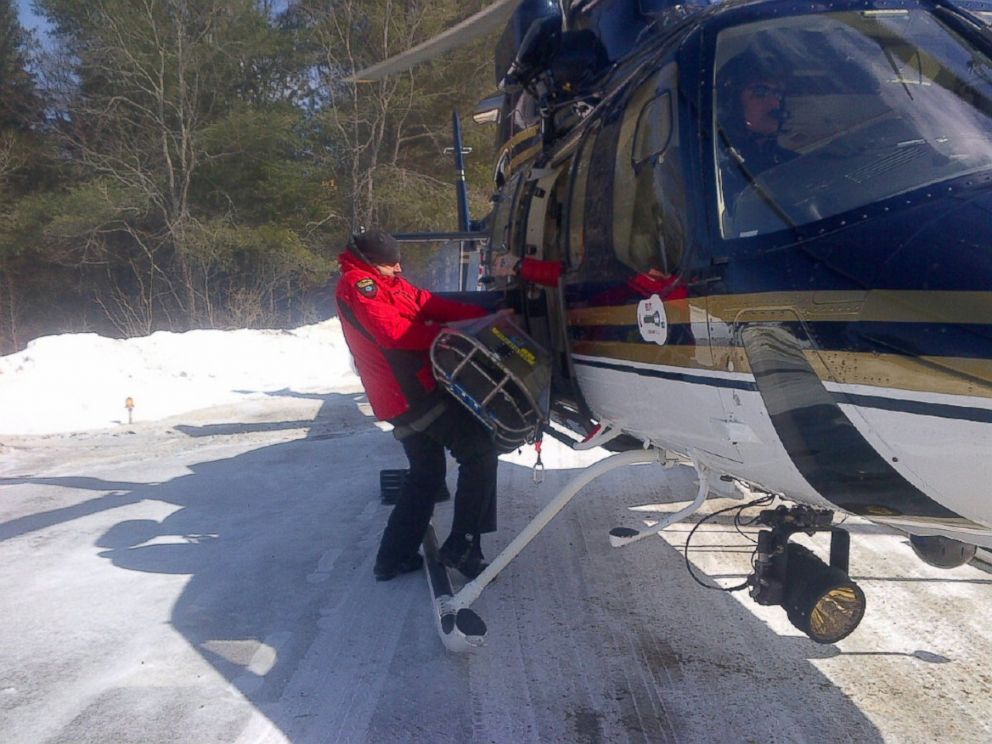 PHOTO: Forest Rangers off load seven year old boy from State Police helicopter. The boy, his eleven year old brother and mother spent the night lost on Mt. Marcy. 
