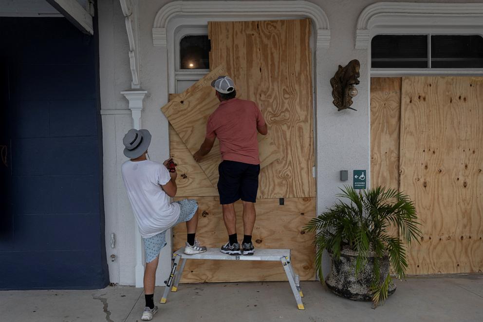PHOTO: Men board up a restaurant window as Hurricane Helene intensifies before its expected landfall on Florida's Big Bend in Cedar Key, Florida on Sept. 25, 2024.