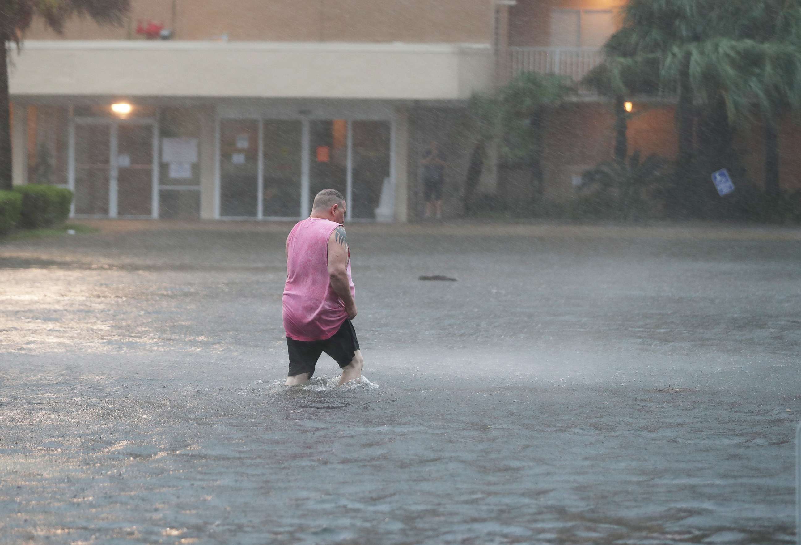 PHOTO: GULF SHORES, ALABAMA - SEPTEMBER 15: A man walks though a flooded parking lot as the outer bands of Hurricane Sally come ashore on September 15, 2020 in Gulf Shores, Alabama. 