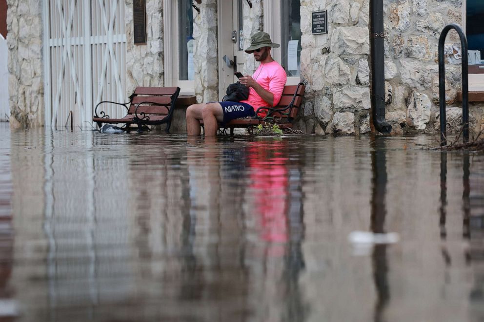 PHOTO: Eliah Corcoran sits on a bench in flood waters after Hurricane Idalia passed offshore on Aug. 30, 2023 in Crystal River, Fla.