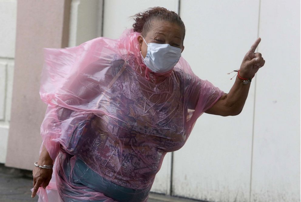 PHOTO: A woman shuts her eyes as she struggles to make her way into the Hard Rock Hotel & Casino during heavy winds, Aug. 4, 2020, in Atlantic City, N.J.