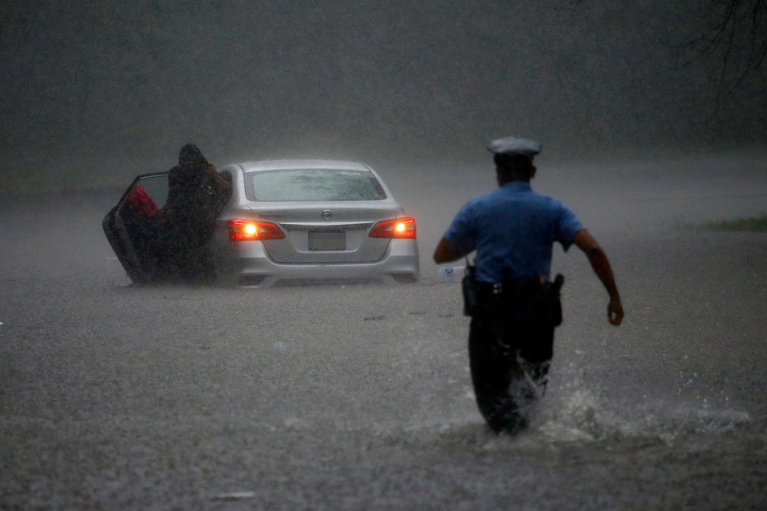 PHOTO: A police officer rushes to help a stranded motorist during Tropical Storm Isaias, Aug. 4, 2020, in Philadelphia.