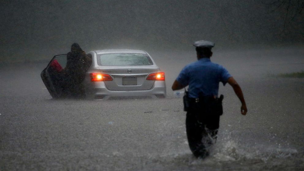 PHOTO: A police officer rushes to help a stranded motorist during Tropical Storm Isaias, Aug. 4, 2020, in Philadelphia.