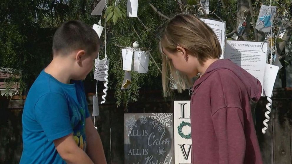 PHOTO: Resident Jackson,8, and Layla, 10, read notes from the Wishing Tree in VIsta, California.