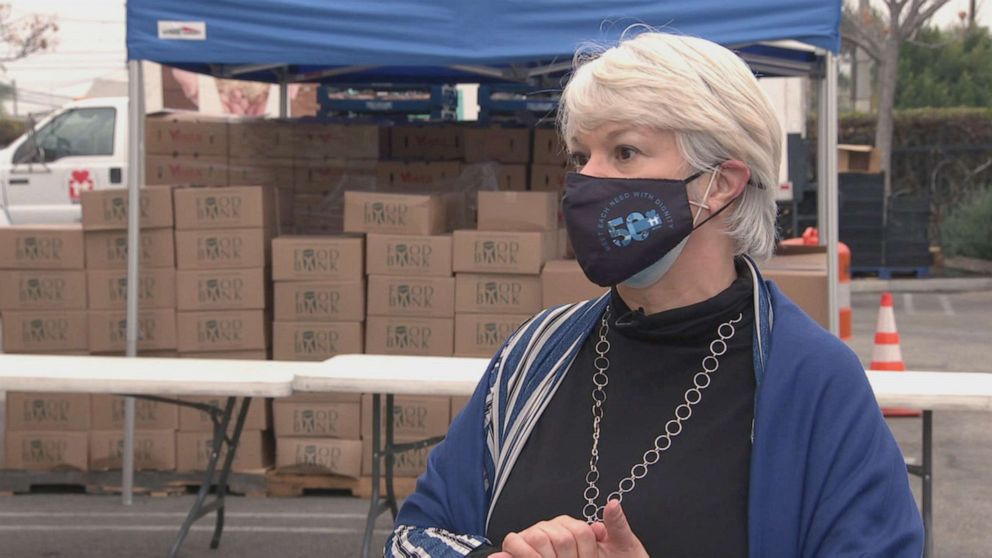 PHOTO: Janet Marinaccio speaks to ABC News’ Zohreen Shah about the lines of people waiting for food at the MEND food bank. 
