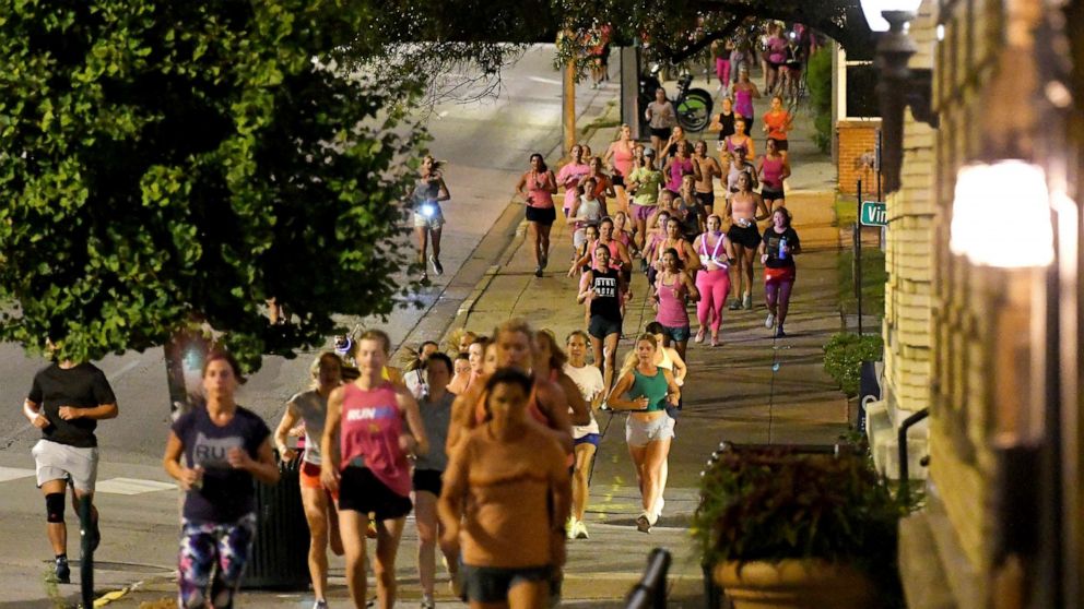 PHOTO: Runners head down the sidewalk past Fountain Square on Georgia Avenue during "Finish Eliza's Run," Sept. 9, 2022 in Chattanooga, Tenn. 