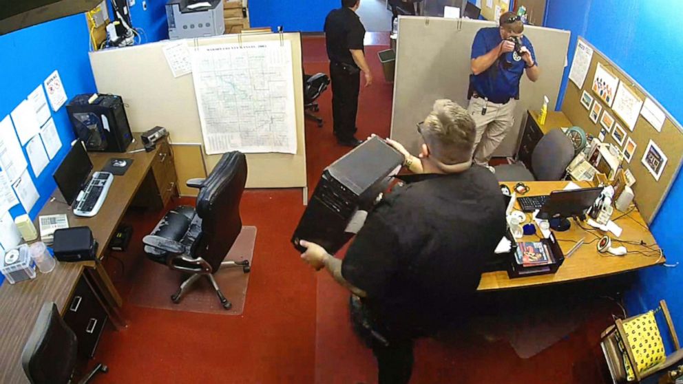 PHOTO: Surveillance video shows Marion, Kansas, police officers seizing computers and taking photographs during an Aug. 11, 2023, raid on the Marion County Record newspaper.