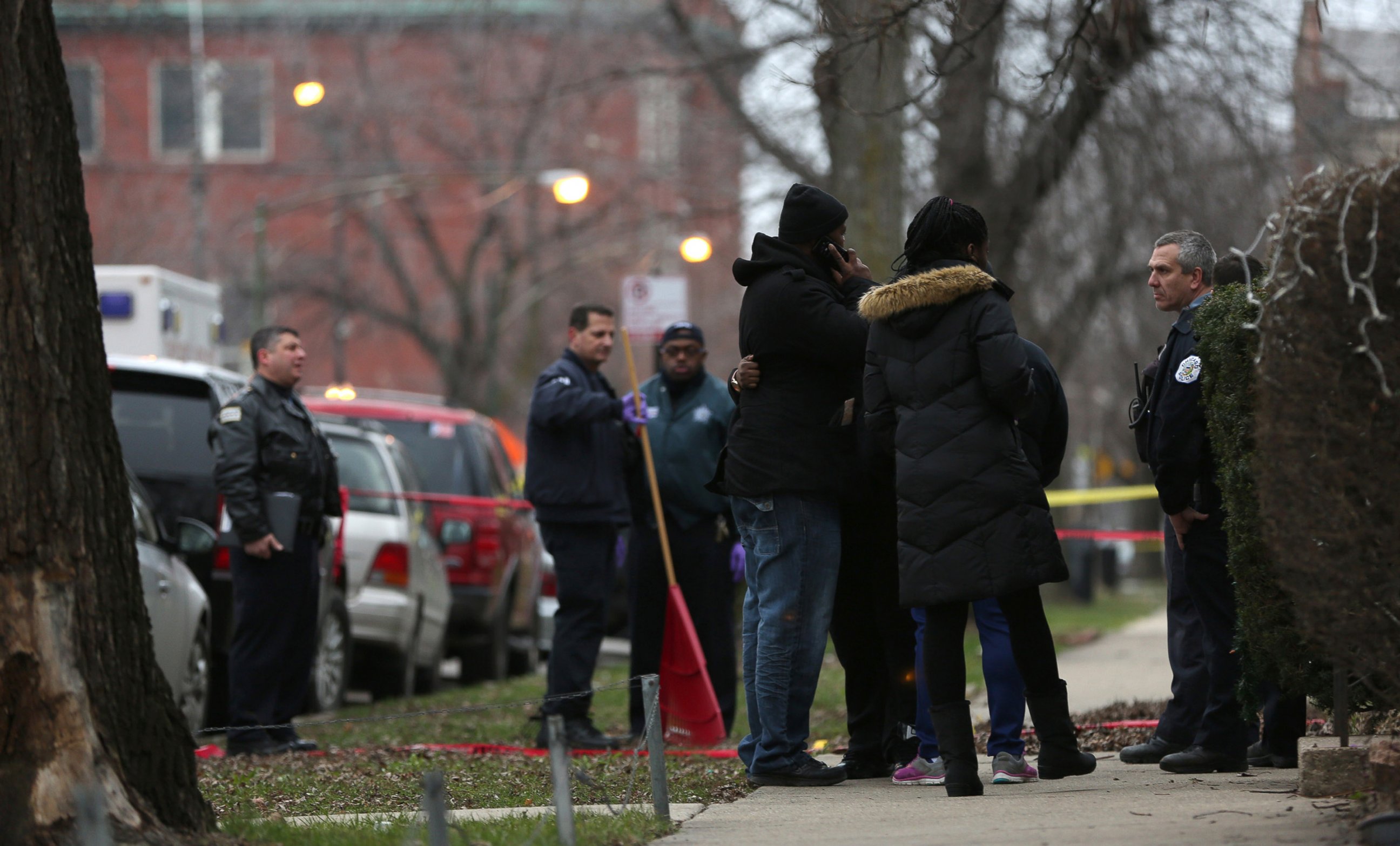 PHOTO: Chicago police talk with relatives of one of the victims as they investigate a double shooting by one of their own, Dec. 26, 2015.