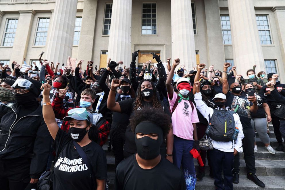PHOTO: LOUISVILLE, KENTUCKY - SEPTEMBER 24: Demonstrators raise their fists as they gather on the steps of the Louisville Metro Hall on September 24, 2020 in Louisville, Kentucky.