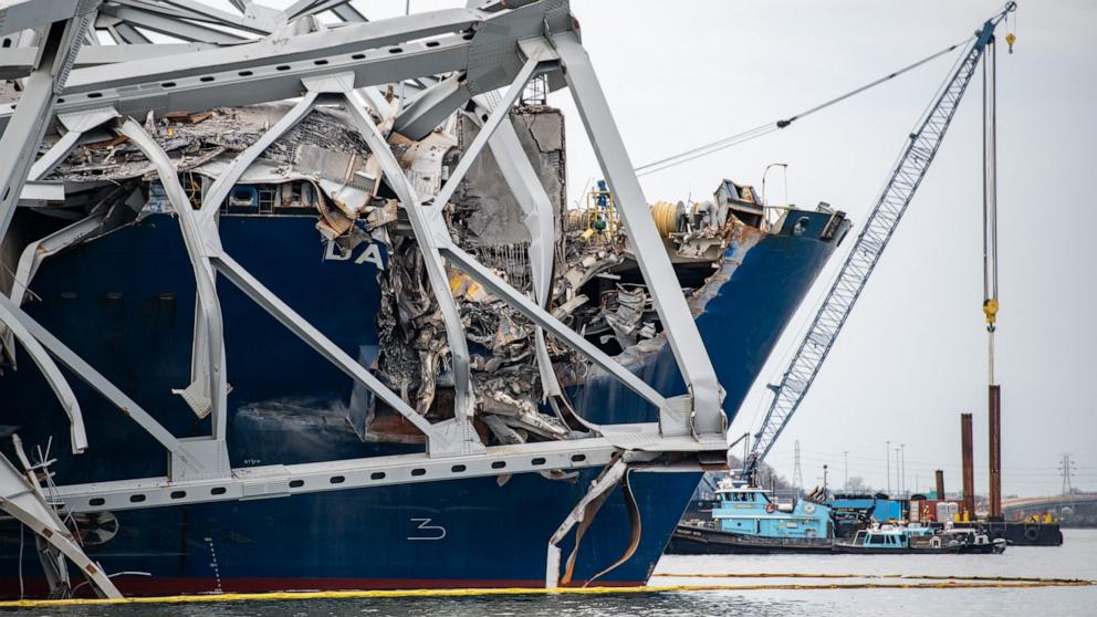PHOTO: This handout photo obtained from the US Coast Guard shows a portion of of the collapsed Francis Scott Key Bridge resting upon the container ship Dali in Baltimore, MD, March 30, 2024. 
