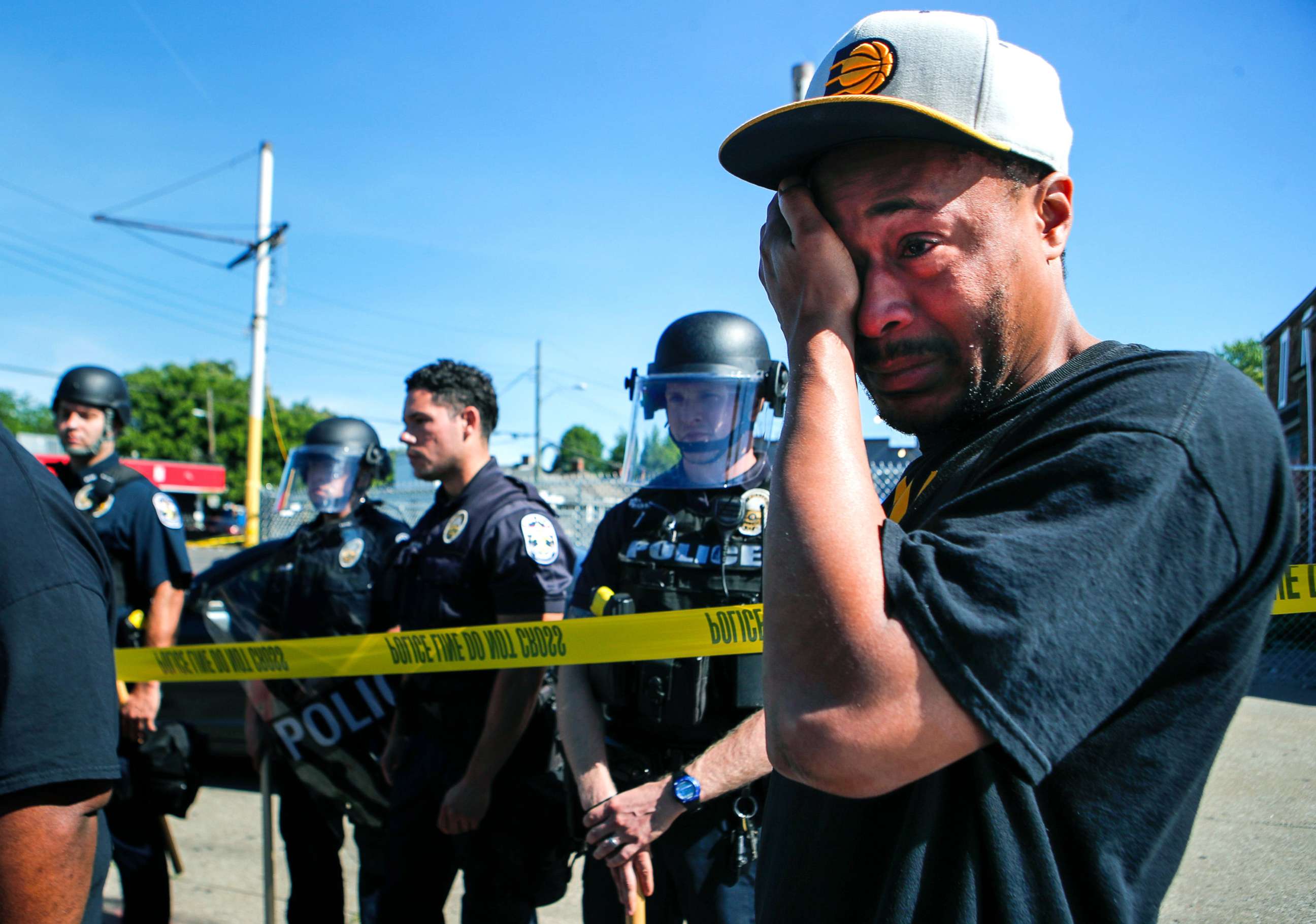 PHOTO: Will Pitts, 39, wipes away tears at the intersection of 26th and Broadway Monday morning after friend and beloved BBQ owner David McAtee was shot and killed by law enforcement outside Dino's Market, June 1, 2020.