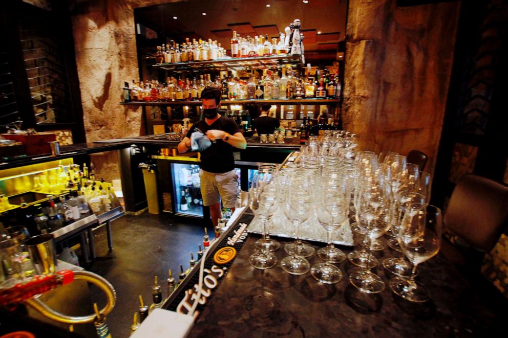 PHOTO: In this Aug. 13, 2020 photo, Mark Hemminger, general manager for Carnevor Steakhouse, cleans glasses in the Milwaukee restaurant in anticipation of opening during the Democratic National Convention. 