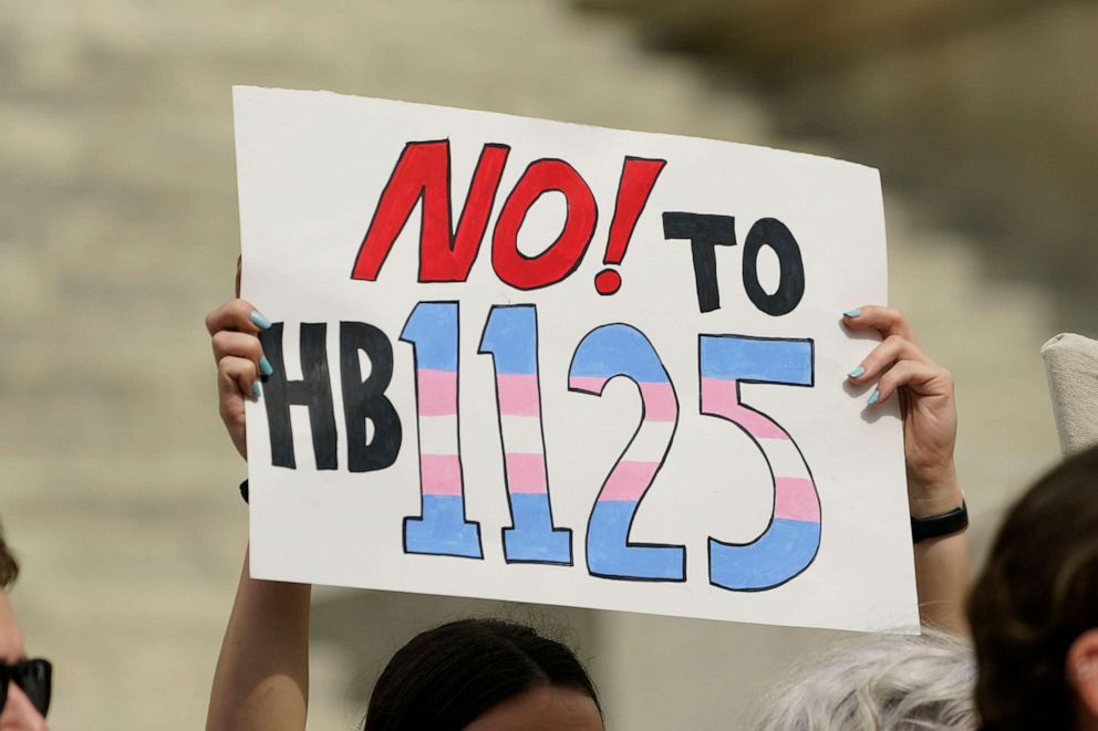 PHOTO: A protester holds a poster calling for lawmakers to vote against House Bill 1125, which would ban gender-affirming care for trans children, Feb. 15, 2023, at the Capitol in Jackson, Miss.