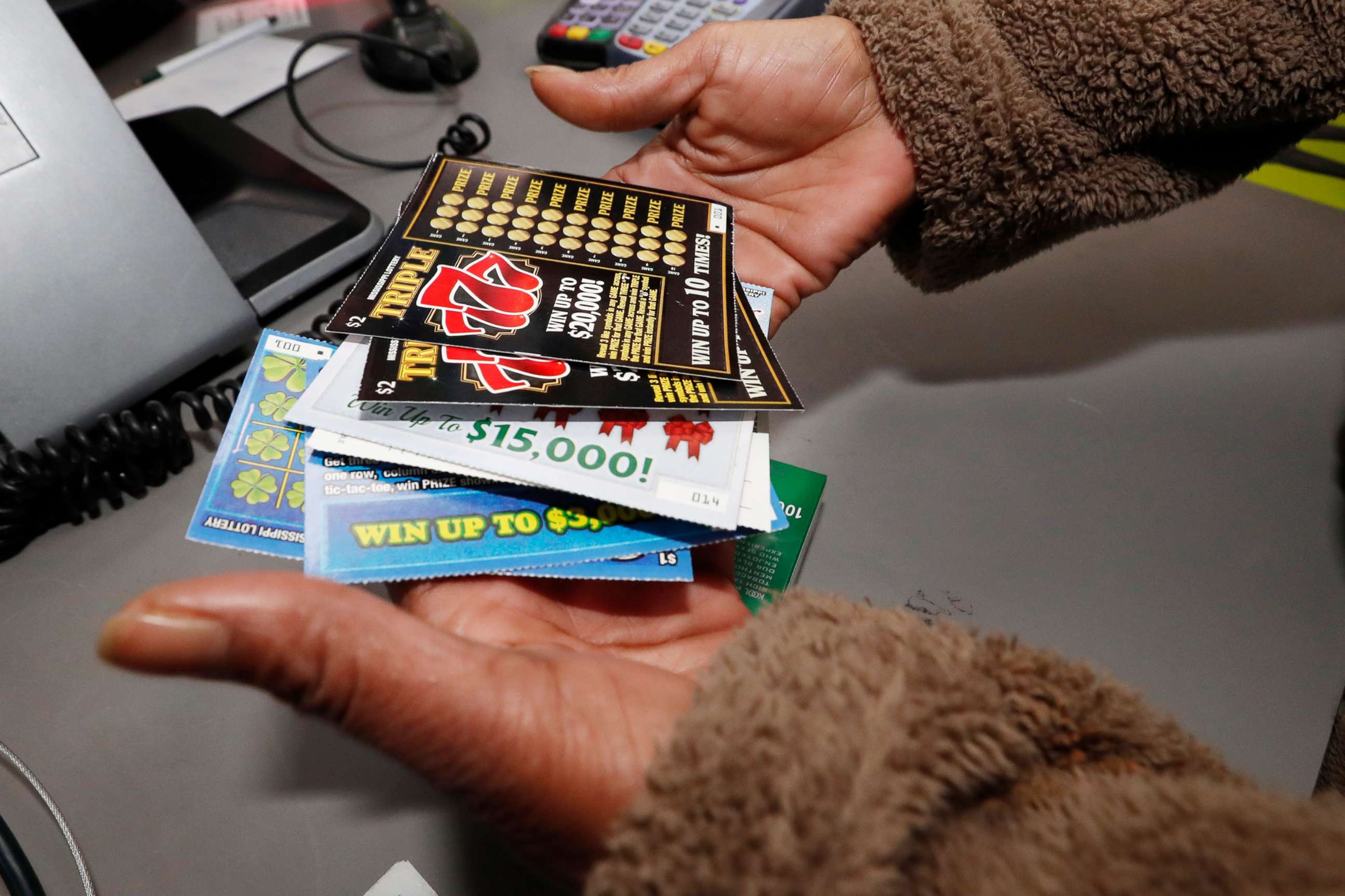 PHOTO: A customer shows her scratch-off tickets after making an early morning purchase from at a Jackson. Miss. RaceWay store, Nov. 25, 2019. Licensed lottery retailers in the state began selling tickets Monday. 