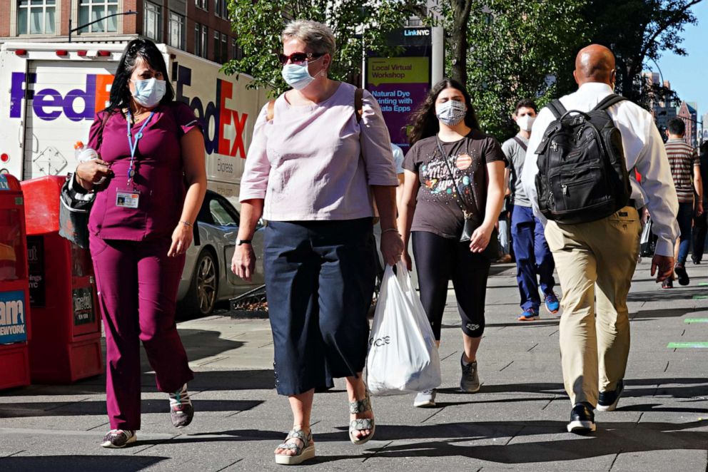 PHOTO: People walk while wearing protective masks as New York City moves into Phase 3 of re-opening following restrictions imposed to curb the coronavirus pandemic, July 14, 2020. 