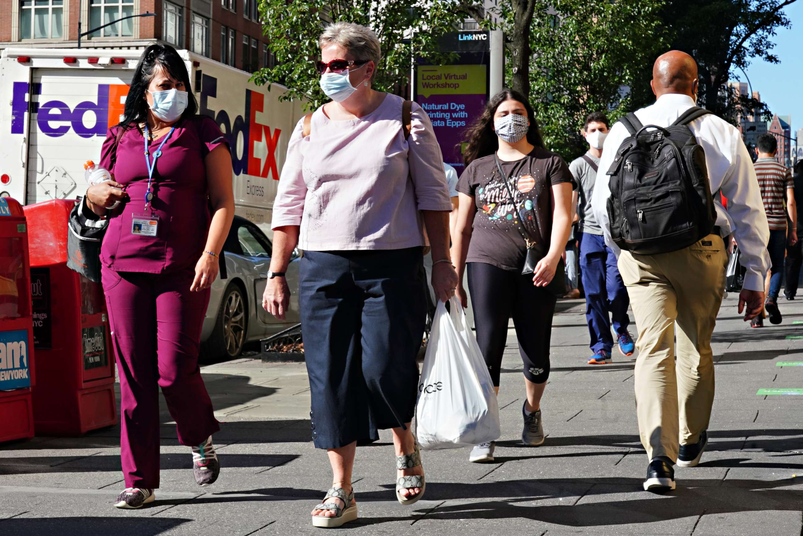 PHOTO: NEW YORK, NEW YORK - JULY 14: People walk while wearing protective masks as New York City moves into Phase 3 of re-opening following restrictions imposed to curb the coronavirus pandemic on July 14, 2020.