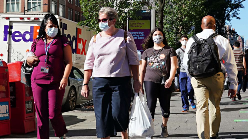 PHOTO: NEW YORK, NEW YORK - JULY 14: People walk while wearing protective masks as New York City moves into Phase 3 of re-opening following restrictions imposed to curb the coronavirus pandemic on July 14, 2020.