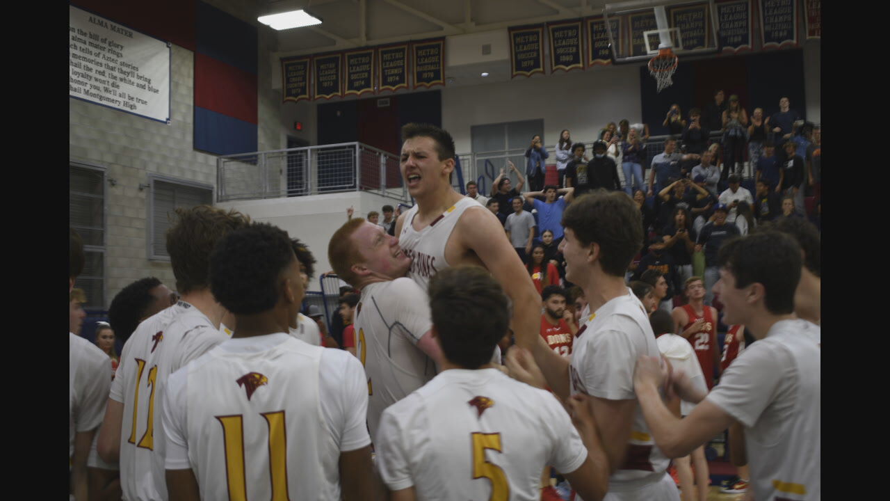 PHOTO: Nick Herrmann and his teammates celebrate after winning the basketball division championship. 