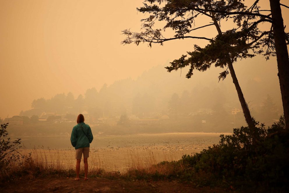 PHOTO: A woman looks at a town by the Pacific Ocean coast as smoke from wildfires covers an area near Yachats, Oregon, U.S., September 8, 2020. 