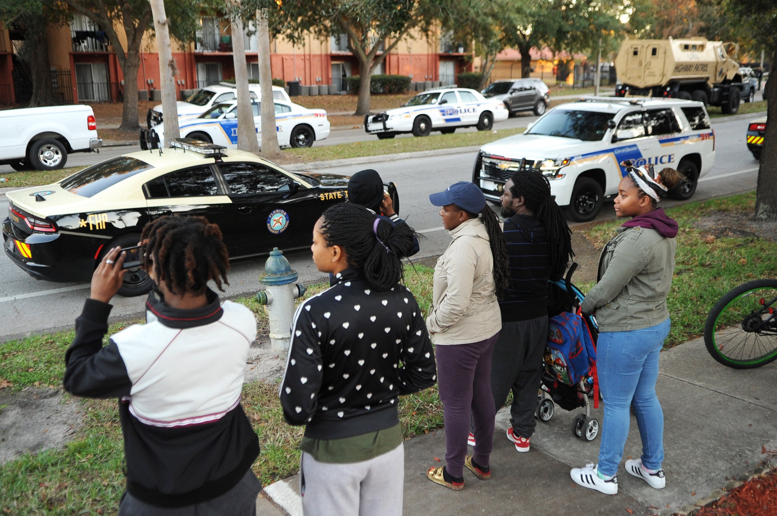 PHOTO: Residents watch as police search the Tzadik Brookside apartment complex in Orlando, Florida, for Markeith Loyd, a suspect in the shooting death of an Orlando, Florida police officer, on Jan. 9, 2017, outside an Orlando Walmart store. 