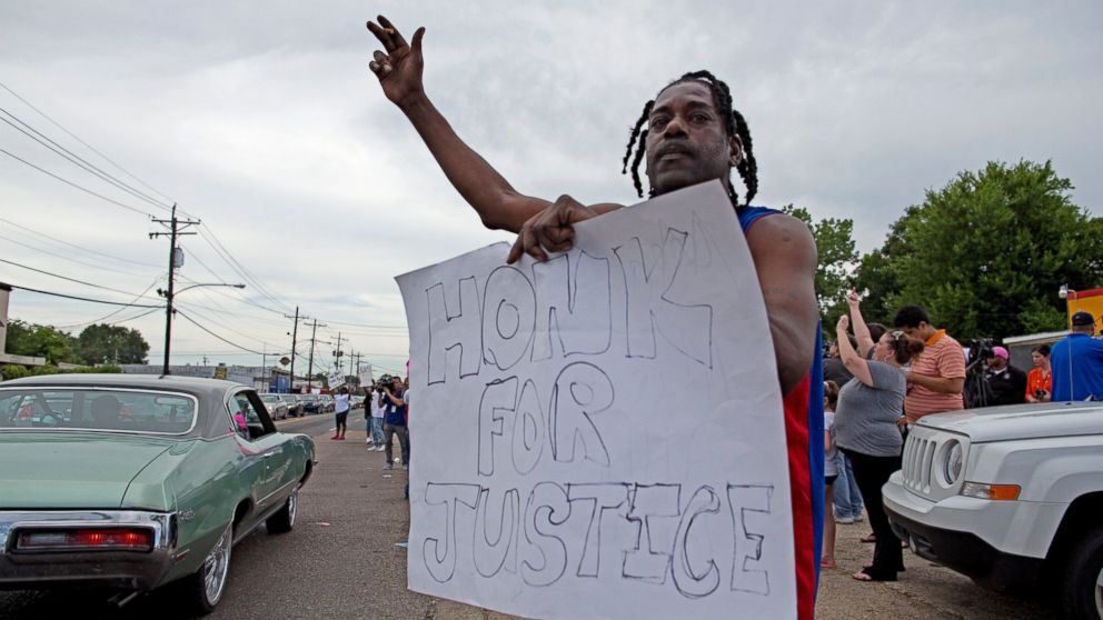 PHOTO: Protesters outside the Triple S convenience store hold signs July 6, 2016, supporting justice for Alton Sterling, a black man who was shot and killed there by Baton Rouge Police officers.