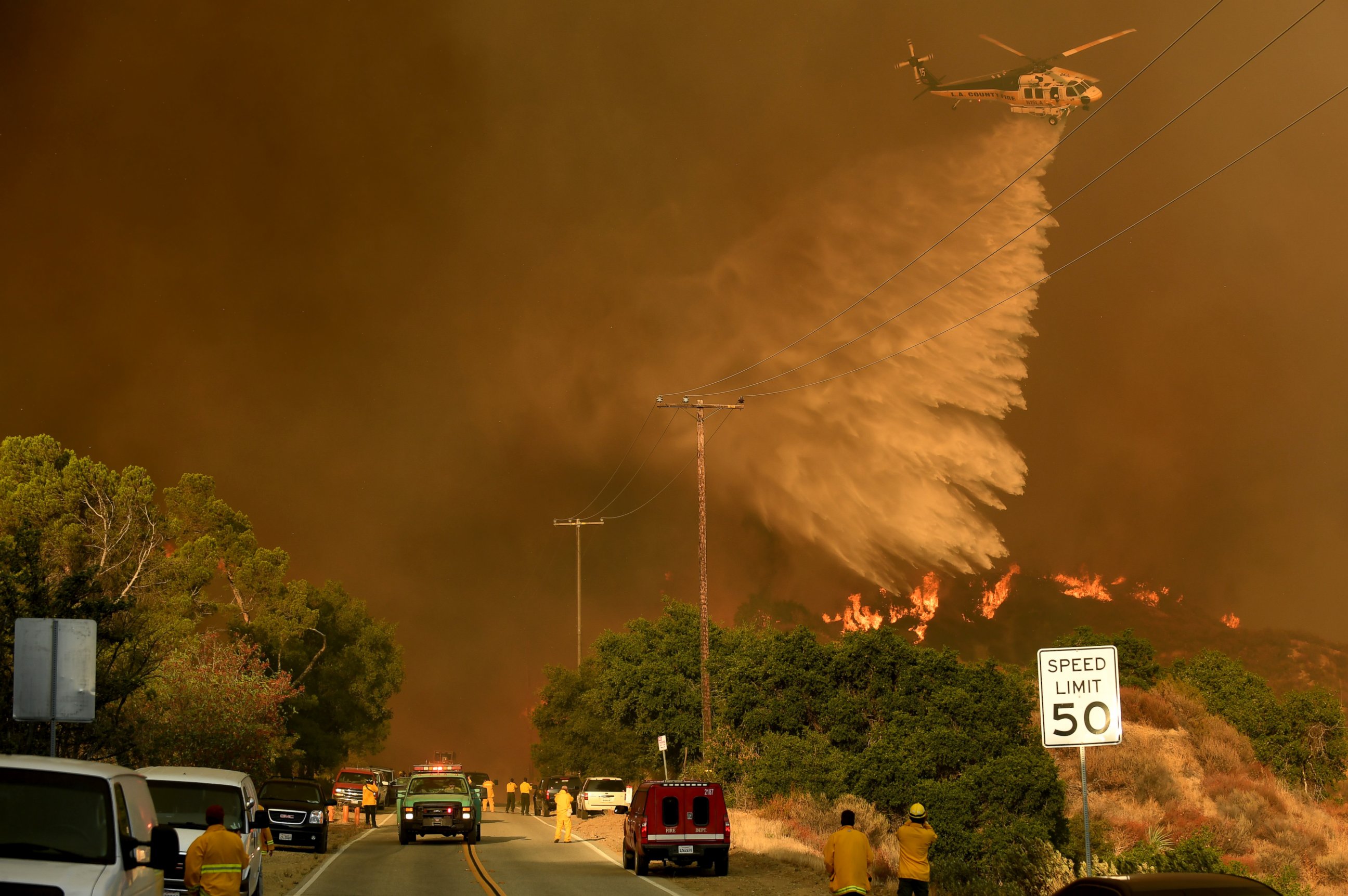 PHOTO: An L.A. County water dropping helicopter makes a drop along Placerita Canyon Road as the Sand Fire burns in the San Gabriel Mountains, July 24, 2016, in Santa Clarita, California.