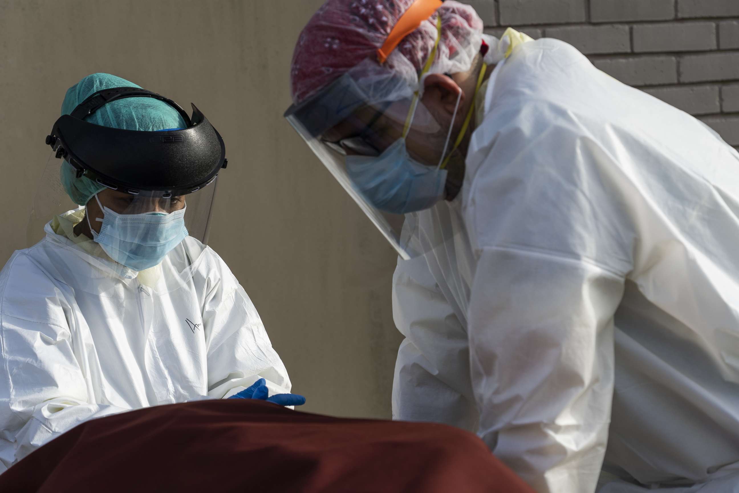 PHOTO: HOUSTON, TX - JUNE 30: Medical staff wearing full PPE wait for a car to pick up a deceased patient outside of  the Covid-19 intensive care unit at the United Memorial Medical Center on June 30, 2020 in Houston, Texas. 