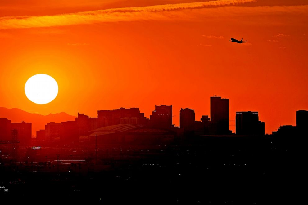 PHOTO: A jet takes flight from Sky Harbor International Airport as the sun sets over Phoenix, July 12, 2023.