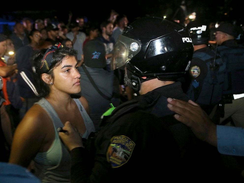 PHOTO: A protester confronts a police officer who is part of a battalion blocking the gate of the Yolanda Guerrero Cultural Center in Guaynabo, Puerto Rico, July 21, 2019.