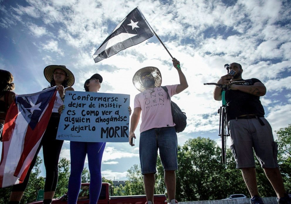 PHOTO:People hold up a black and white Puerto Rican flag to signify resistance and grief during a rally on the Las Americas Highway in San Juan, Puerto Rico, July 22, 2019.