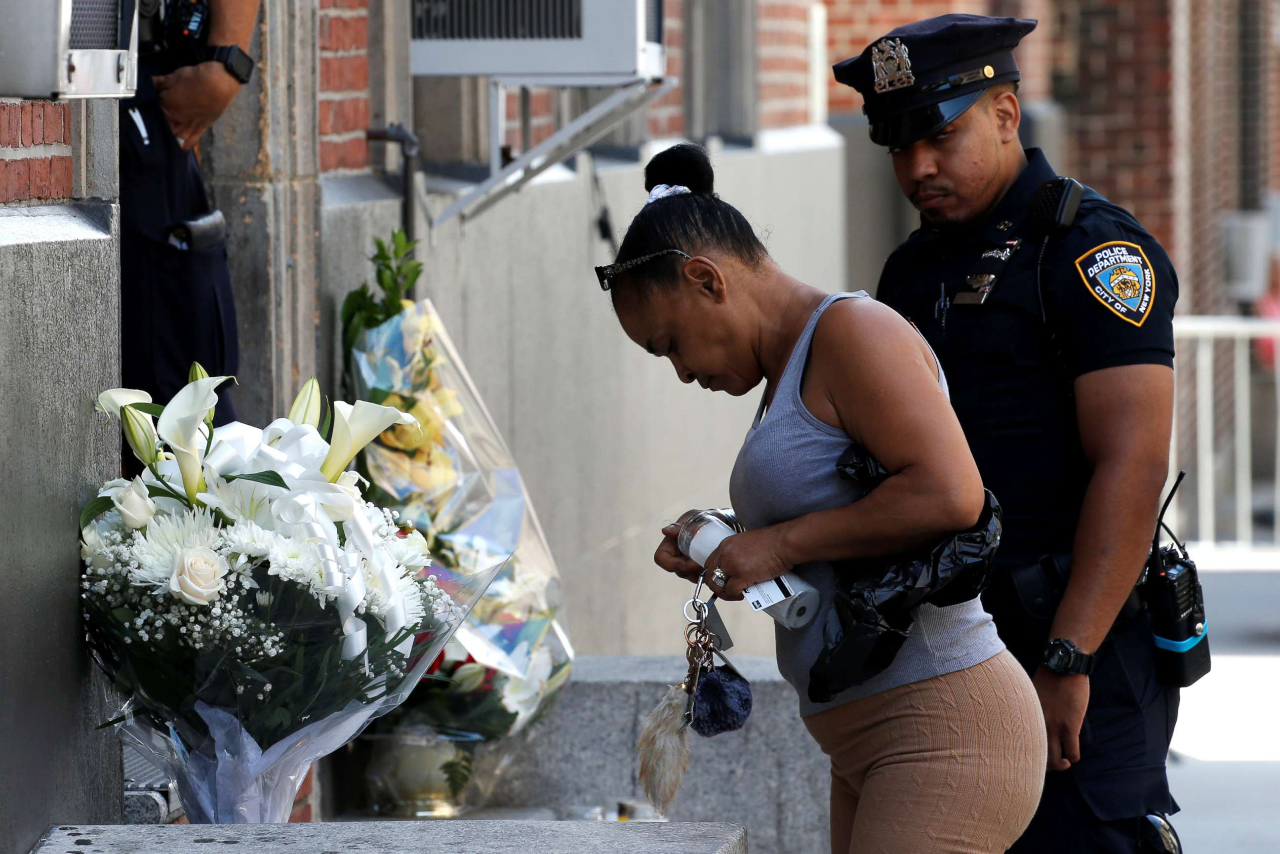 PHOTO: Local resident Maria Ramos places a candle at a makeshift memorial outside the New York City Police Department's 46th precinct after a gunman fatally shot a female officer in an unprovoked attack in the Bronx, New York, on July 5, 2017.