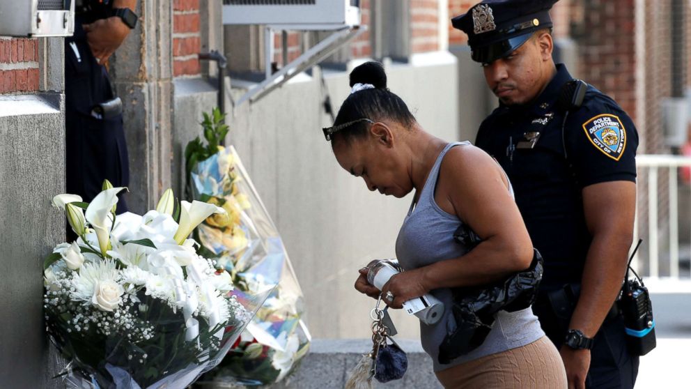 PHOTO: Local resident Maria Ramos places a candle at a makeshift memorial outside the New York City Police Department's 46th precinct after a gunman fatally shot a female officer in an unprovoked attack in the Bronx, New York, on July 5, 2017.