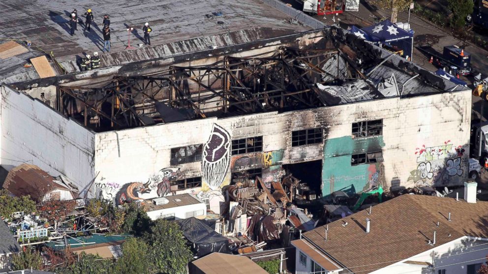 PHOTO: Recovery teams examine the charred remains of the two-story converted warehouse that caught fire killing dozens in Oakland, California, Dec. 4, 2016.