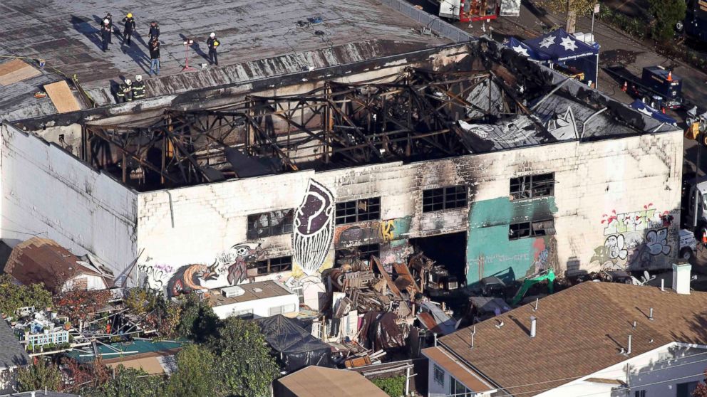 Recovery teams examine the charred remains of the two-story converted warehouse that caught fire killing dozens in Oakland, California, Dec. 4, 2016.